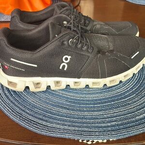 On Running Black Sneakers with Streamlined Design and Reflective Details